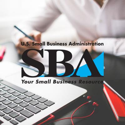 Photo of part of a laptop with a person writing on a notepad in the background, overlaid with the US Small Business Administration logo